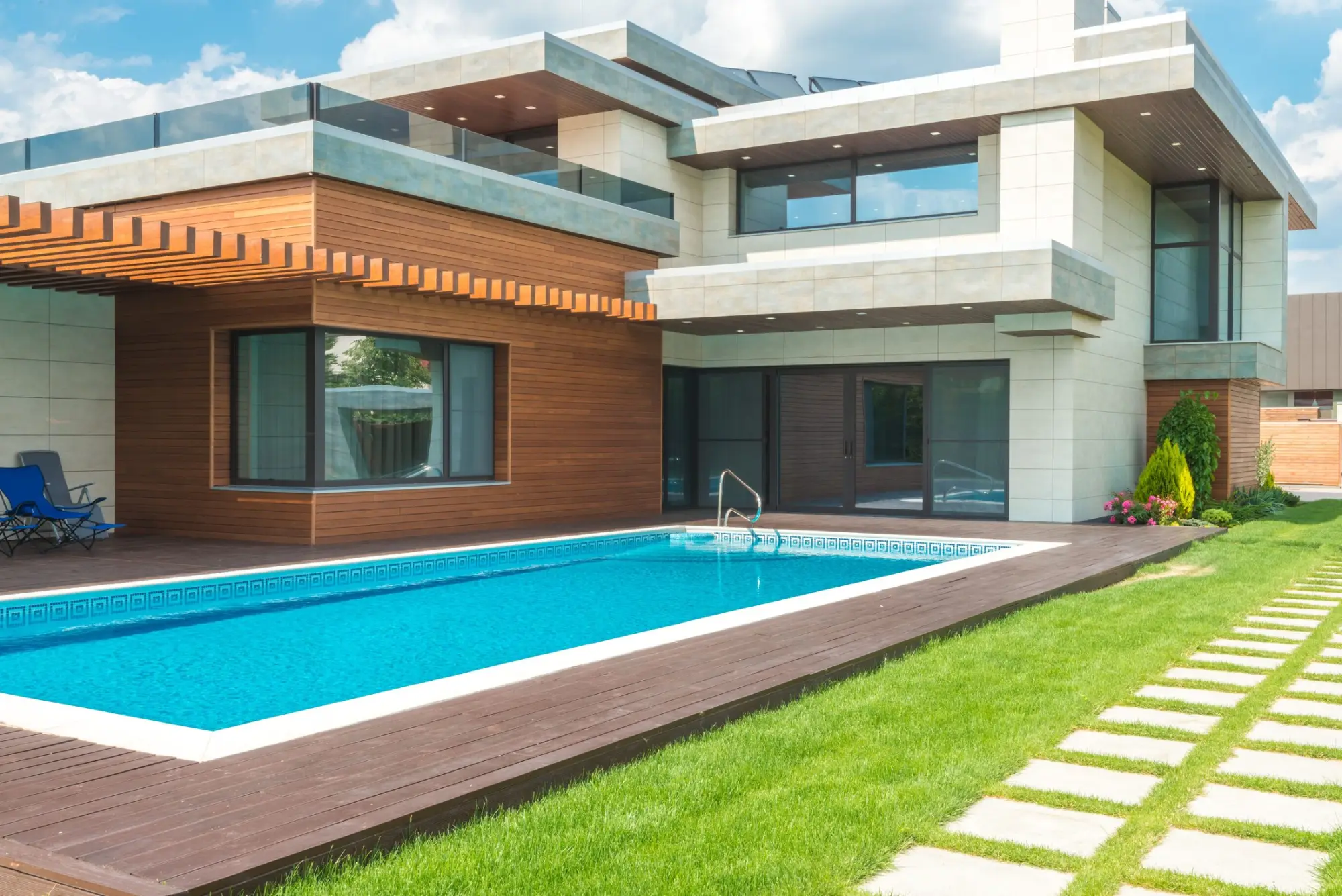 Contemporary home with timber cladding and a rectangular pool set into a lawn